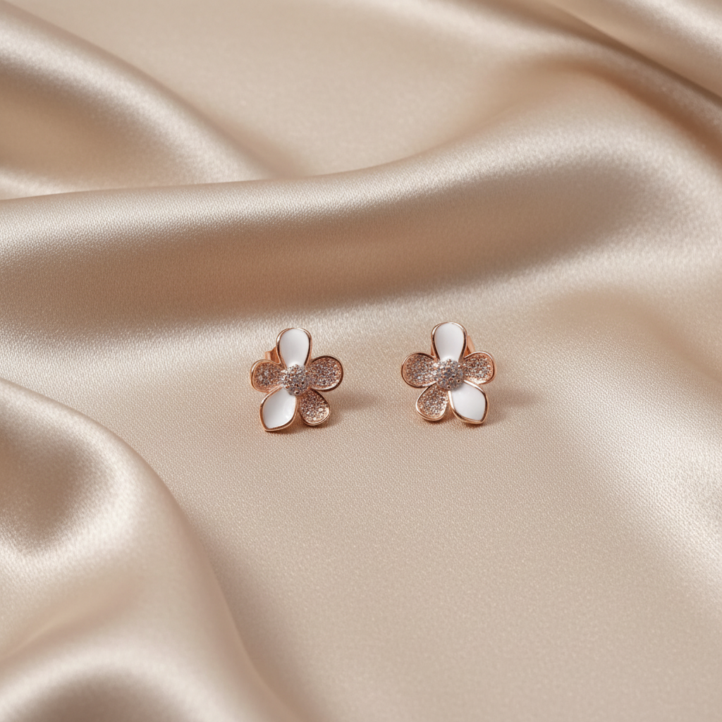 Rose gold flower earrings on neutral silky fabric