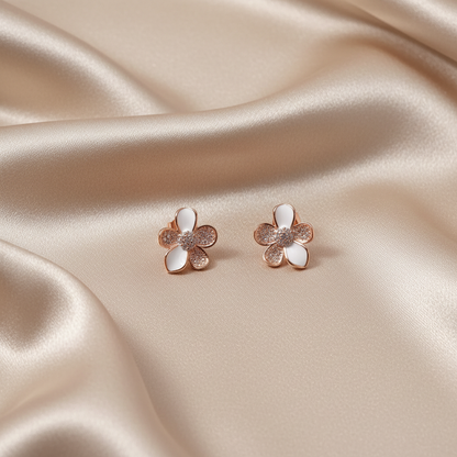 Rose gold flower earrings on neutral silky fabric